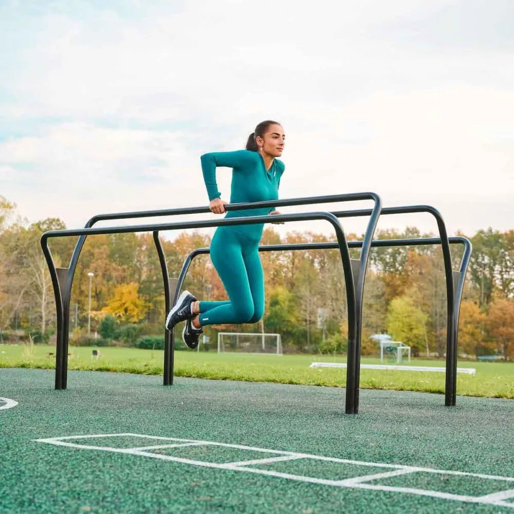Athlete aligning stride beside wooden fence rails on pasture